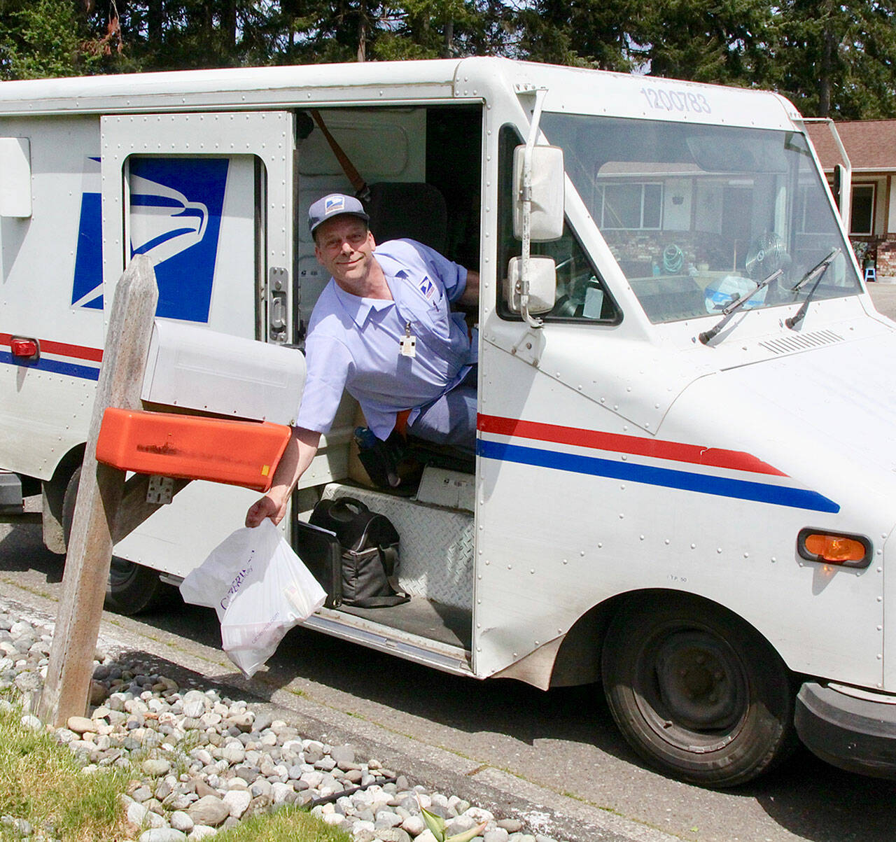 Alex Baker of the USPS picks up some food donations on his west Port Angeles route several years ago. (Dave Logan/For Peninsula Daily News)