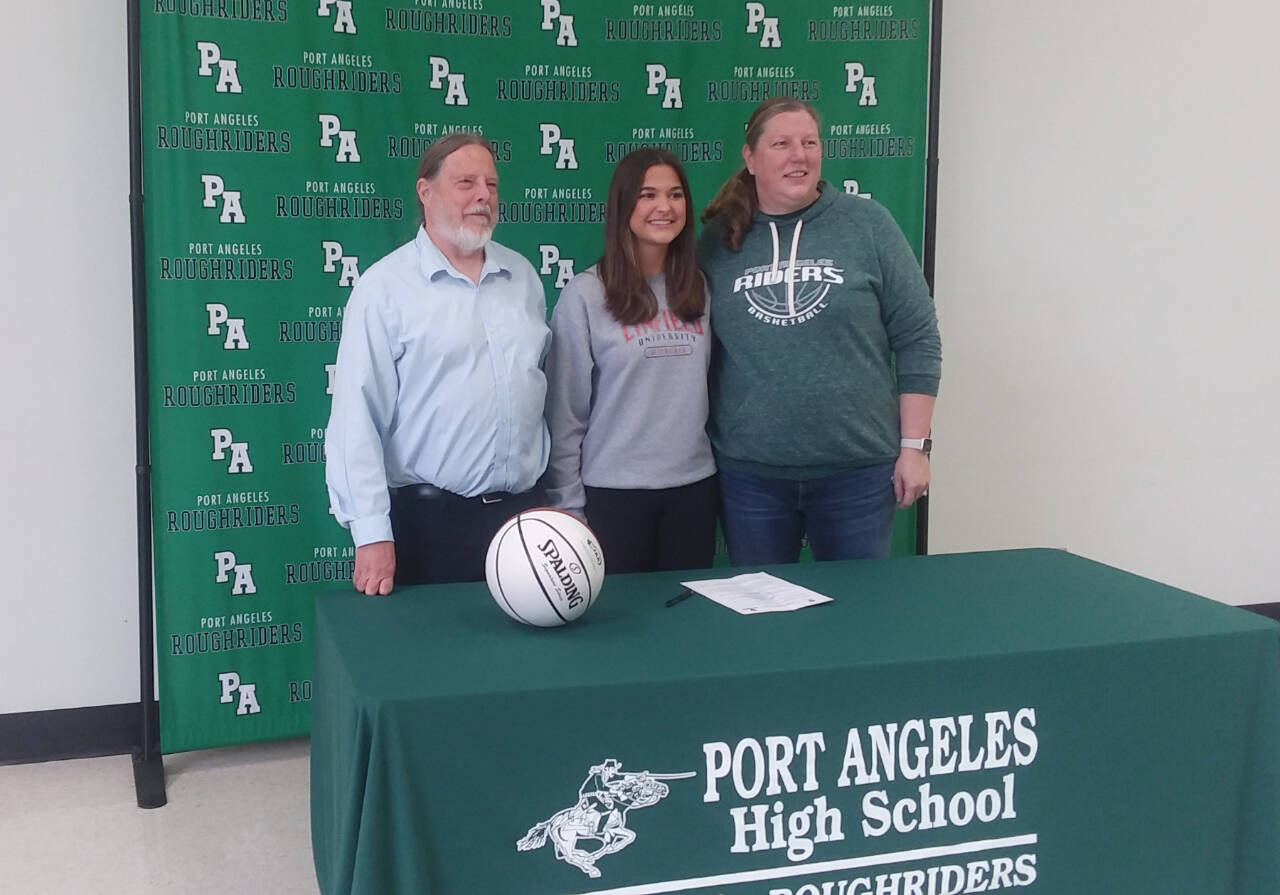 From left, Port Angeles head girls basketball coach Michael Poindexter, Eve Burke and assistant coach Jennifer Rogers at Burke’s signing to play for Linfield College in McMinnville, Ore. (Pierre LaBossiere/Peninsula Daily News)