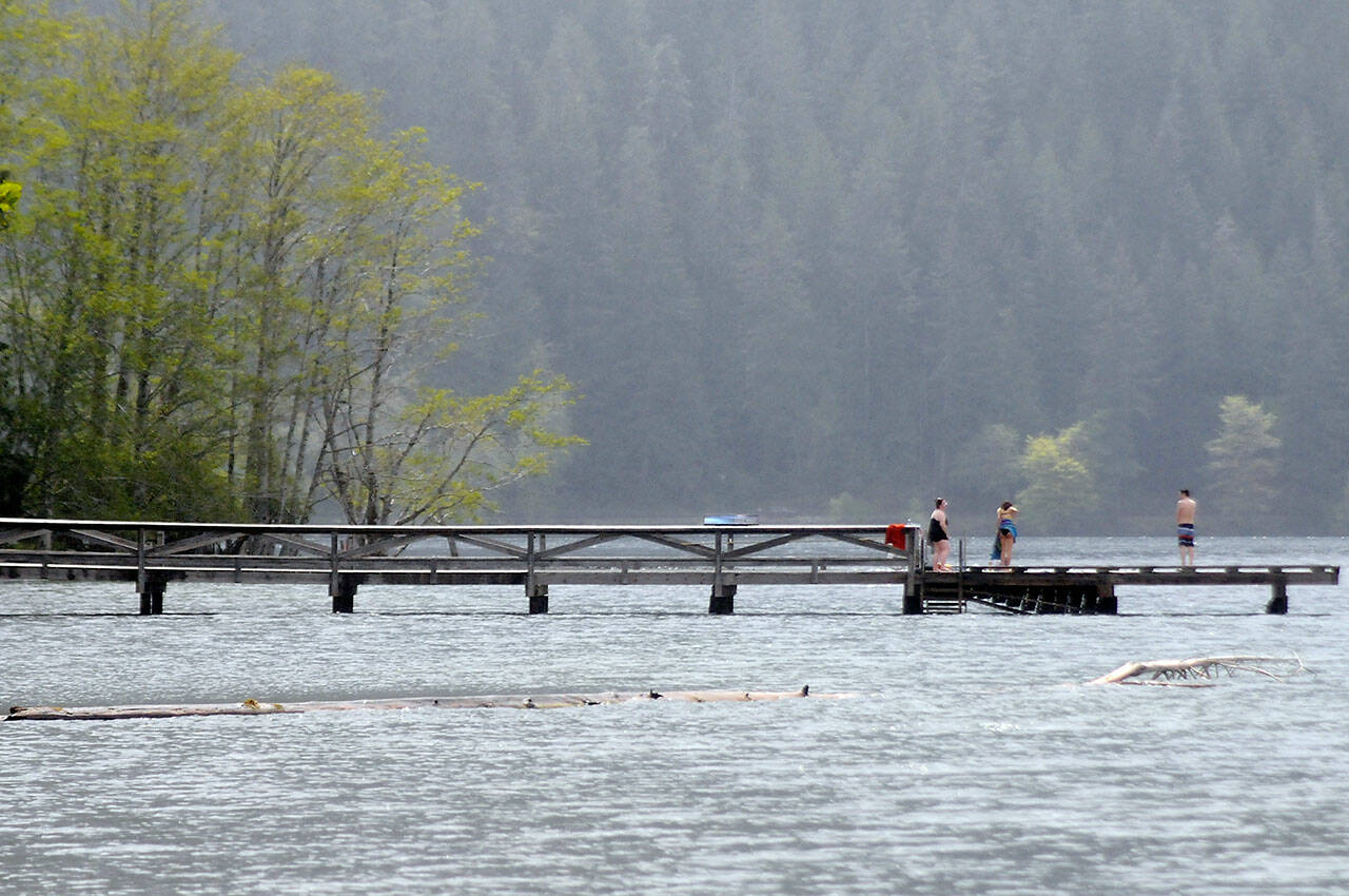 Visitors to Lake Crescent Lodge at Barnes Point contemplate swimming from the lodge’s dock on Tuesday in Olympic National Park southwest of Port Angeles. (Keith Thorpe/Peninsula Daily News)