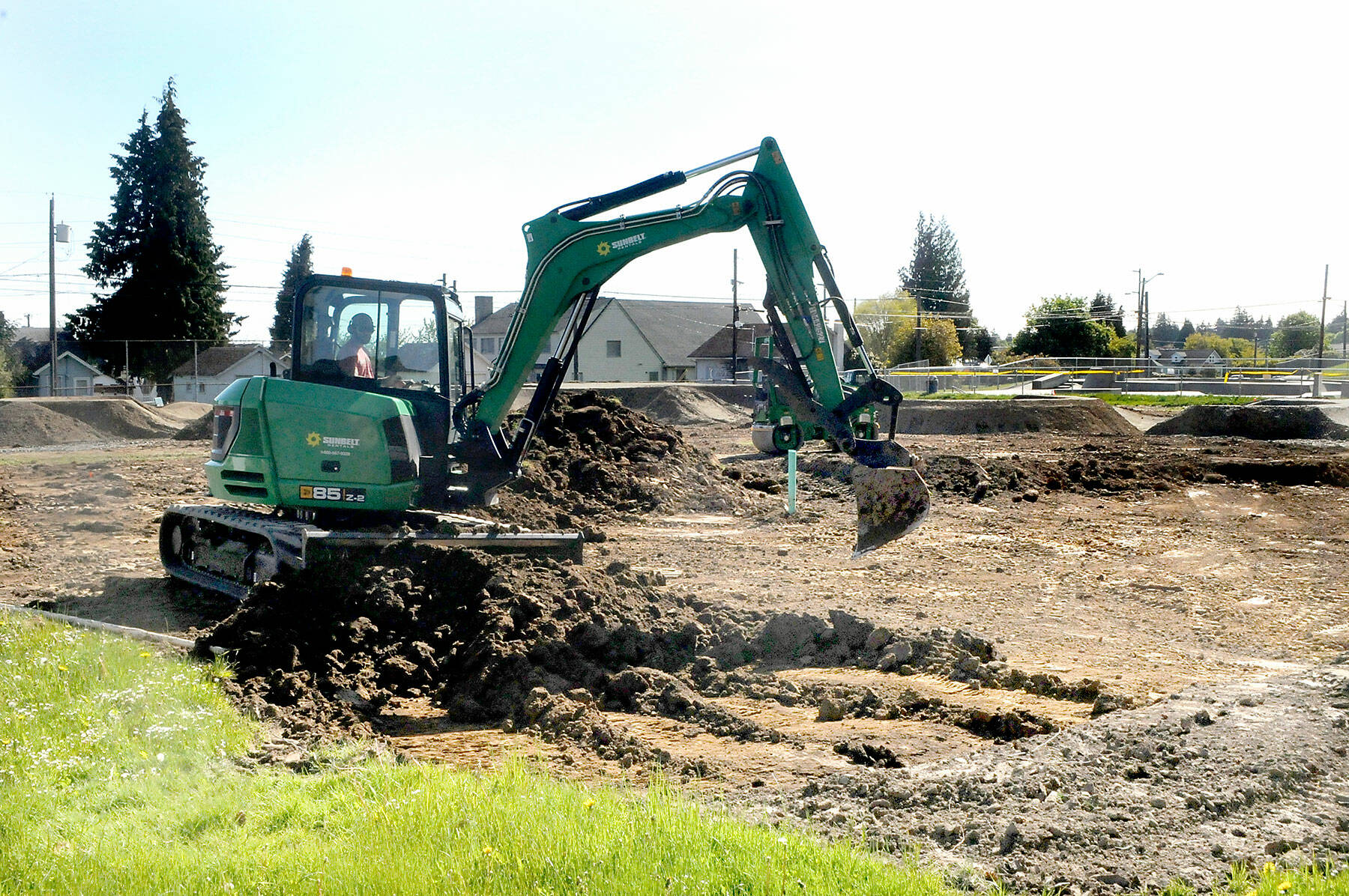 An excavator moves dirt on Thursday at the site of a pump track under construction at Erickson Playfield in Port Angeles. Volunteers are sought to help with asphalt installation from May 25 to June 1. (Keith Thorpe/Peninsula Daily News)
