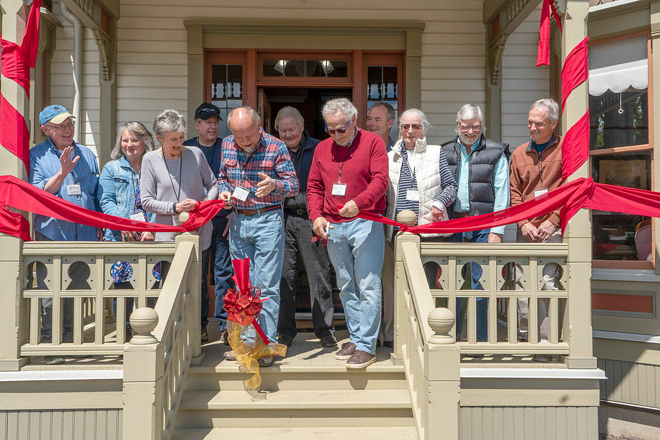 Steve Mullensky/for Peninsula Daily News

Chair of the Board Christine Satterlee, left, holds the ribbon as project managers David Satterlee, left, and Chuck Thrasher wield scissors to cut the ribbon to signal the restoration of the 130-year old Worthington House is complete and open to the public. The cutting took place in Quilcene on Friday.