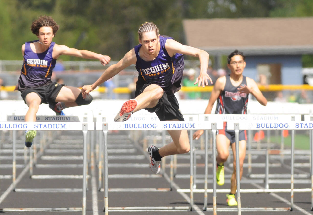 Sequim’s Adrian Brown, center, won the district championship in the 110-meter hurdles. At left is brother Andrew Brown, who came in fifth and second in the high jump. (Michael Dashiell/Olympic Peninsula News Group)