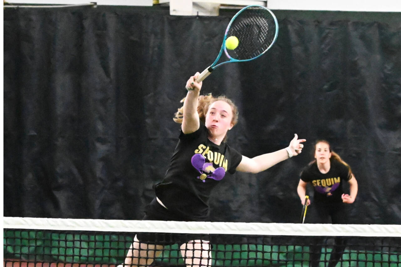 Sequim's Malory Morey returns a volley with teammate Jordan Hegtvedt in the background in the West-Central District 3 tennis tournament held this weekend in Bremerton. Morey and Hegtvedt won two matches at district. (Michael Dashiell/Olympic Peninsula News Group)
