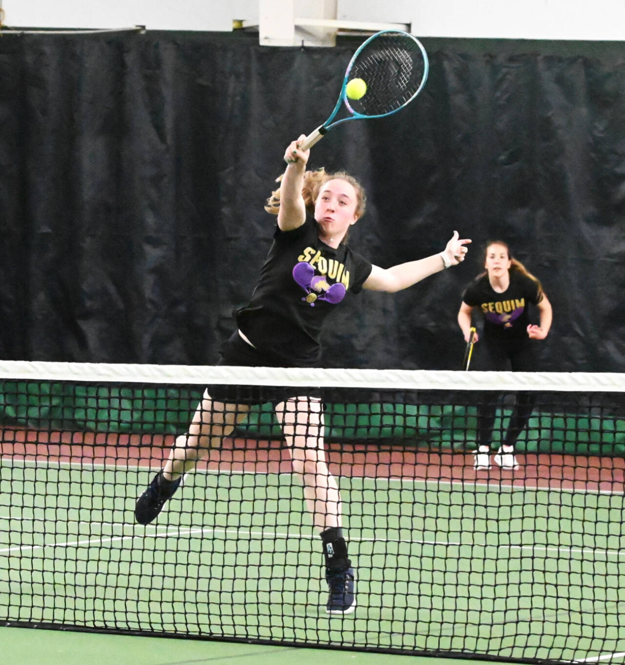 Sequim’s Malory Morey returns a volley with teammate Jordan Hegtvedt in the background in the West-Central District 3 tennis tournament held this weekend in Bremerton. Morey and Hegtvedt won two matches at district. (Michael Dashiell/Olympic Peninsula News Group)