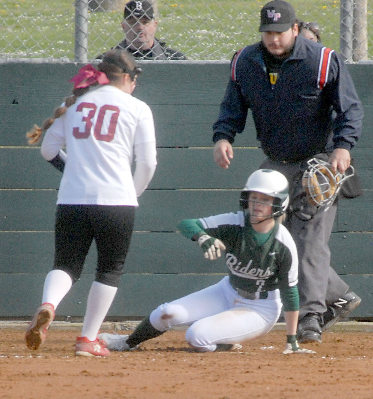Port Angeles baserunner Peyton Rudd looks towards Kingston pitcher Jayla Moon while stealing home after a wild pitch got away from the catcher during a game earlier this season. (Keith Thorpe/Peninsula Daily News)