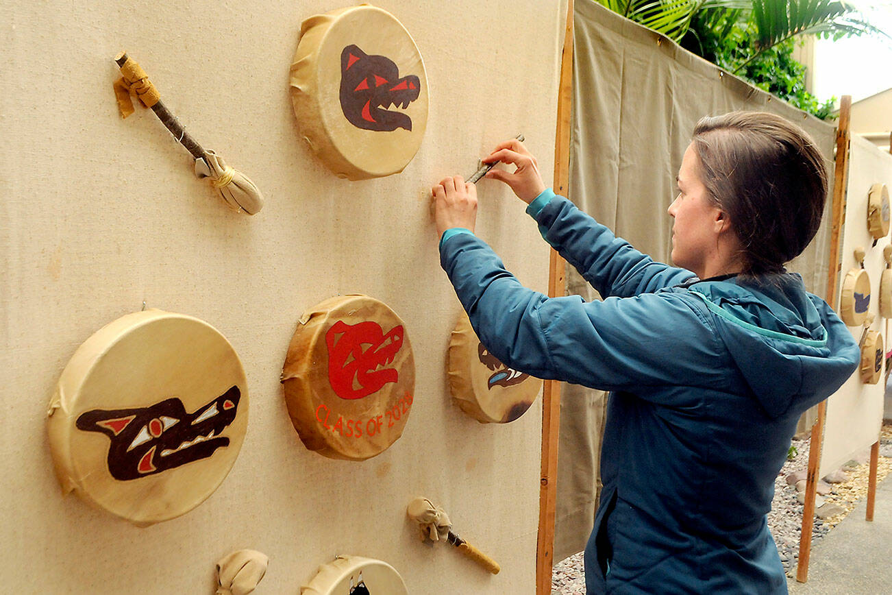 Kaitlin Harrigan of Port Angeles assembles a display of native art by students from Dry Creek School on Thursday that will adorn the atrium at Vern Burton Community Center during this weekend’s Juan de Fuca Festival of the Arts in Port Angeles. (Keith Thorpe/Peninsula Daily News)
