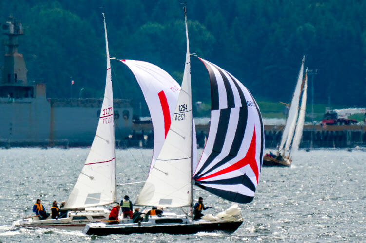 A pair of sloops race to the finish line as the Port Townsend Sailing Association’s Classic Mariners Regatta got underway. The 39th regatta returned after a two-year hiatus due to the COVID-19 pandemic. About 30 sailing vessels, large and small, took part in the annual sailing event Saturday that was open to all designs and materials for the first time. (Steve Mullensky/for Peninsula Daily News)