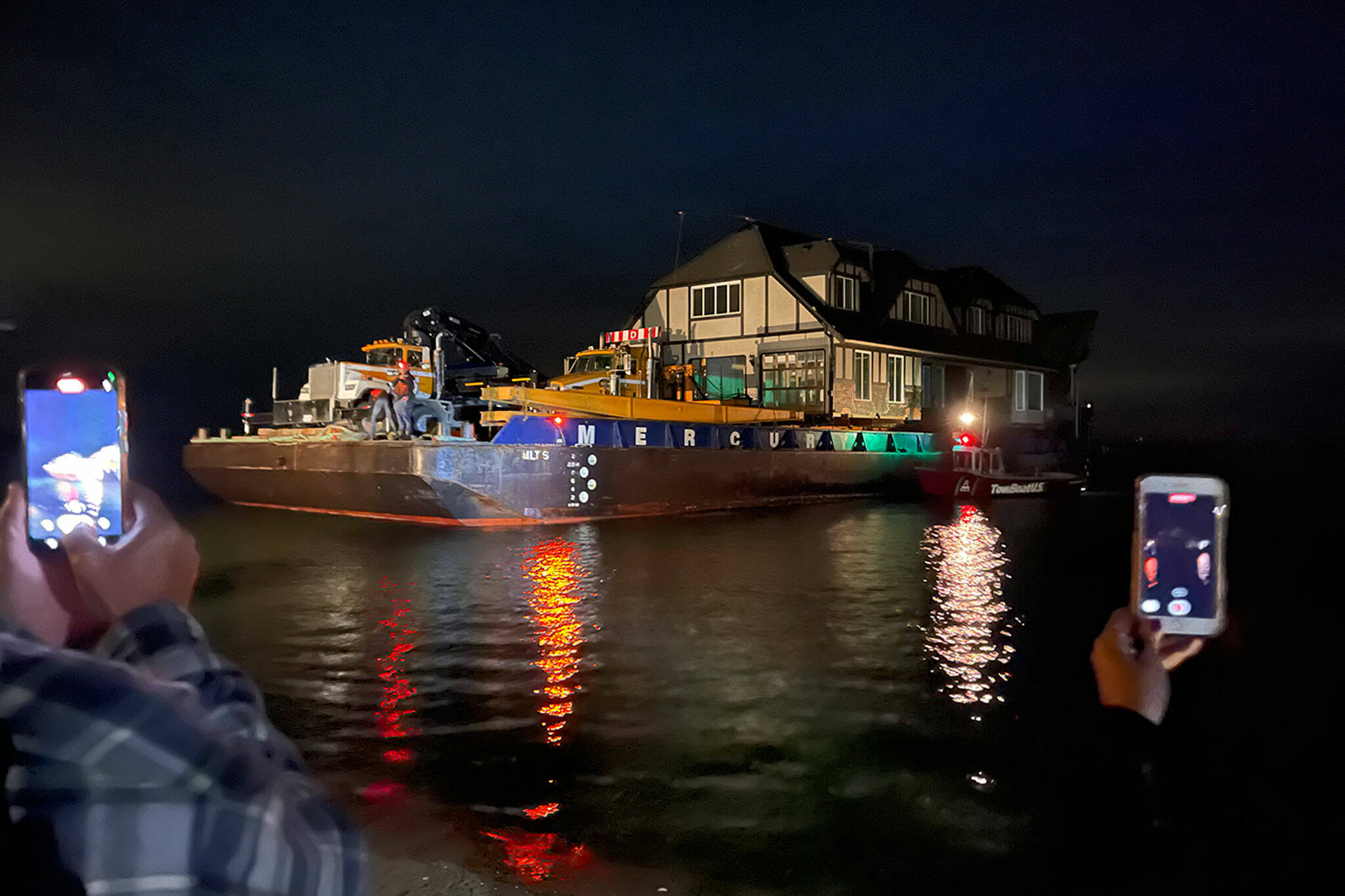 A crowd gathers late on June 8 to watch Martha Vaughan’s new home be delivered by Nickel Bros crew members to its new home on 3 Crabs Road. (Photo courtesy Jeff McCord, Nickel Bros)