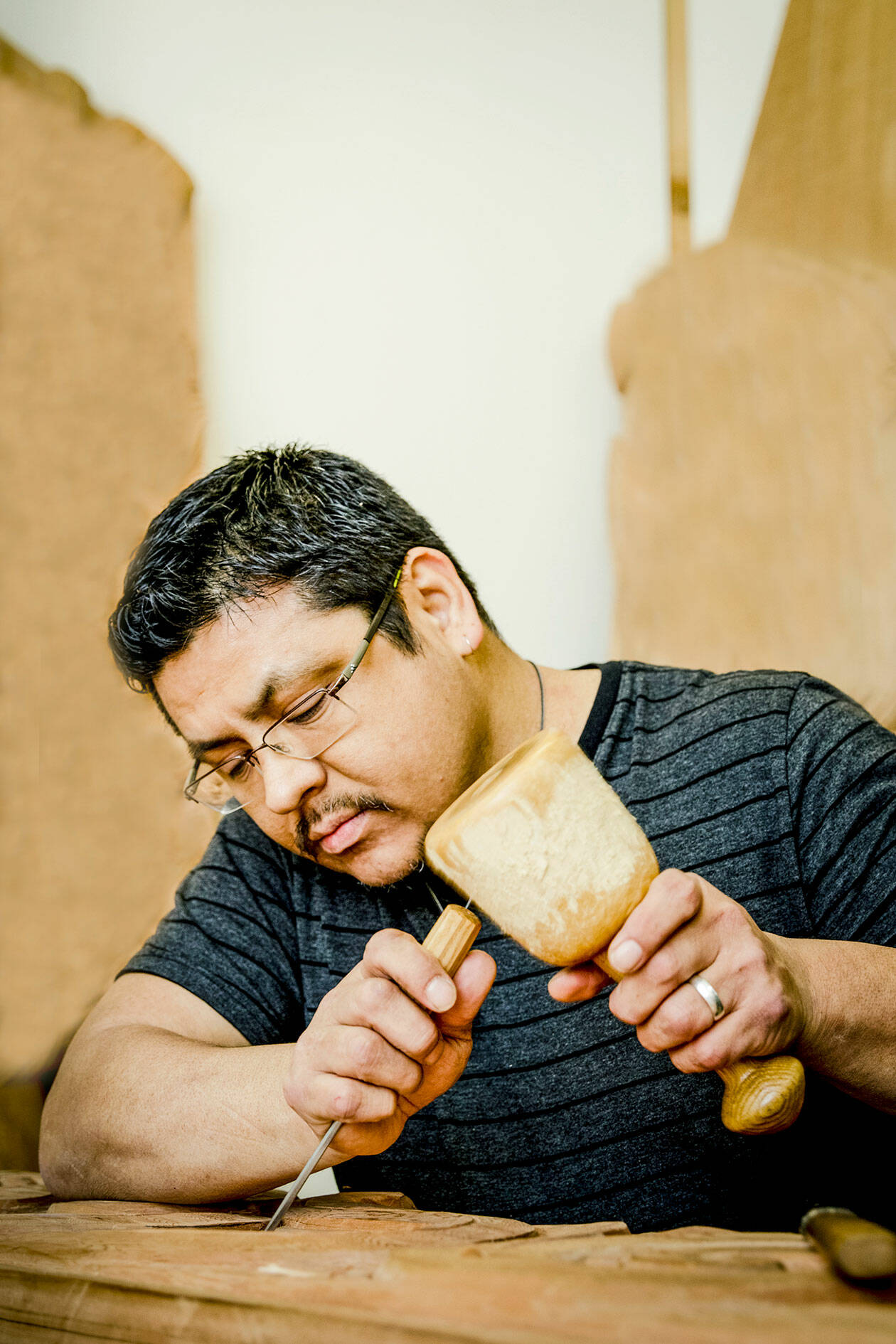 Alex “Swiftwater” McCarty, a Makah artist who will present a lecture, about the Ozette Village, is pictured working on a carving. (Shauna Bittle)