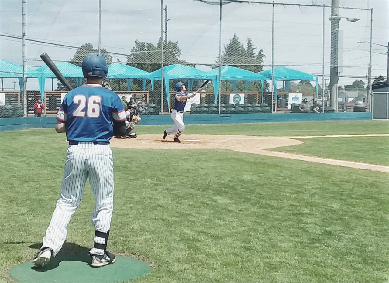 The Port Angeles Lefties' BY Choi hits a fly ball foul as former Port Angeles Roughrider Ethan Flodstrom (26) waits in the on-deck circle Sunday at Civic Field. (Pierre LaBossiere/Peninsula Daily News)