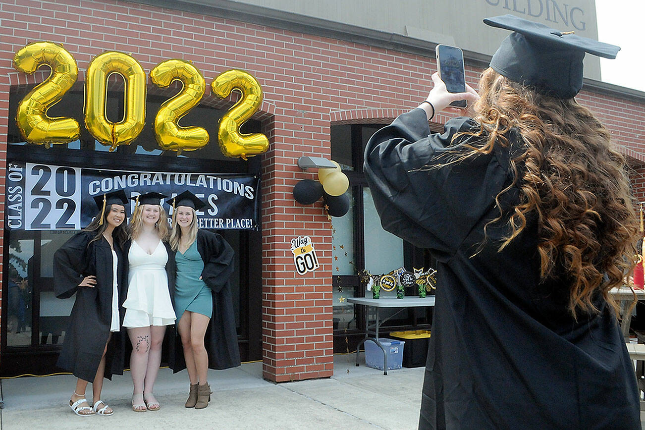 Peninsula College graduate Mackenzie Hammond of Port Angeles, right, take a photograph of fellow students, from left, Myra Luong, Kyrissa Duncan and Julia Biciunas, all of Forks, prior to Saturday’s commencement ceremony at the school’s Port Angeles campus. About 250 students were expected to take part in the ceremony out of about 500 students eligible for degrees and certificates. (Keith Thorpe/Peninsula Daily News)