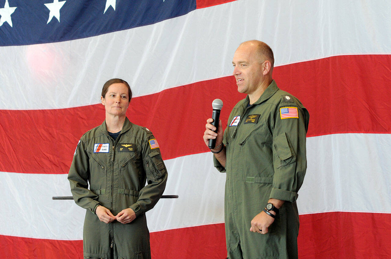 Cmdr. Joan Snaith, outgoing commanding officer of U.S. Coast Guard Air Station/Sector Field Office Port Angeles, left, listens as incoming officer Cmdr. Brent Schmadeke speaks after Thursday’s change of command ceremony. (Keith Thorpe/Peninsula Daily News)