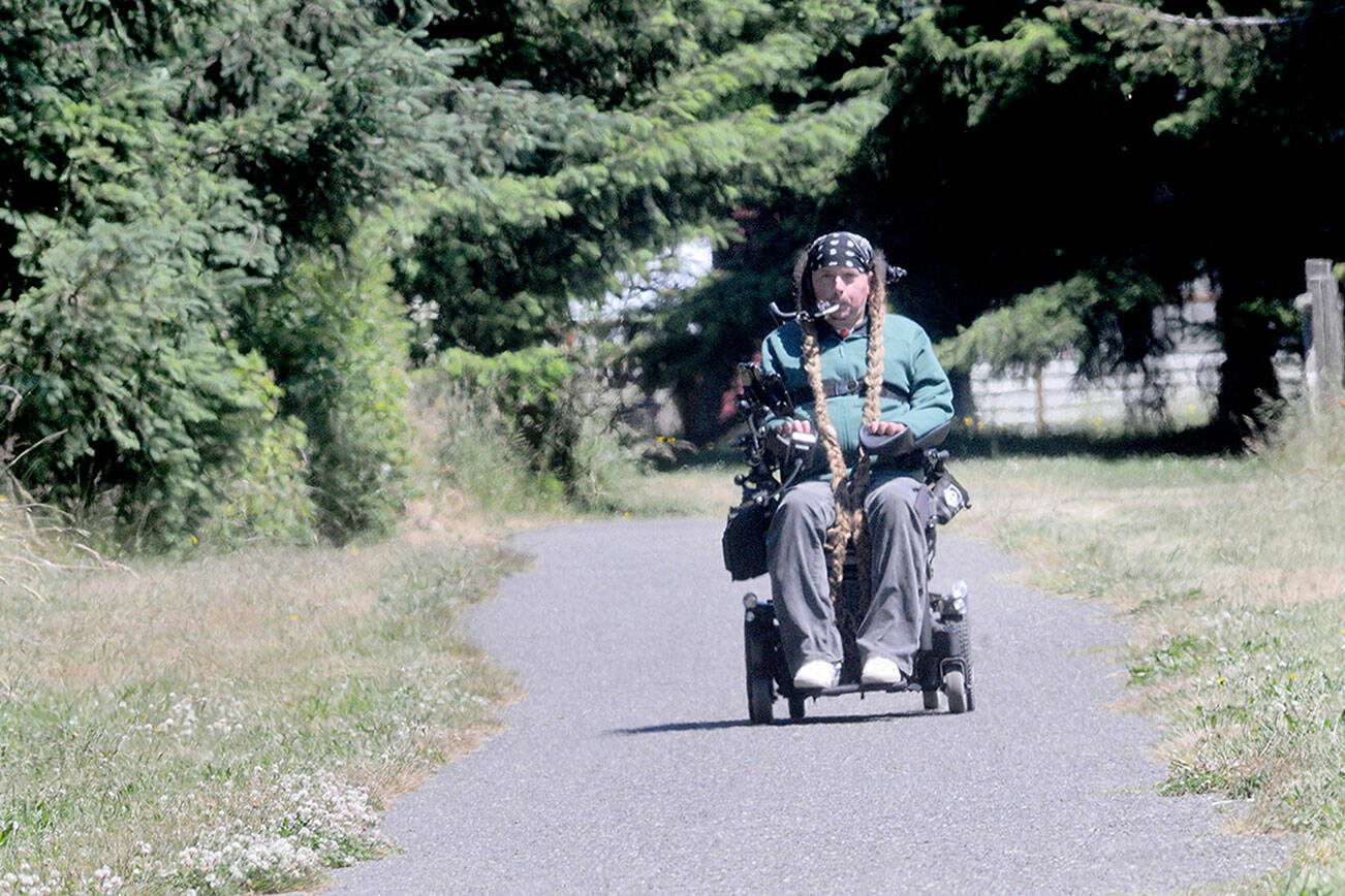 Ian Mackay rides his motorized wheelchair on a section of the Olympic Discovery Trail at Robin Hill County Park west of Sequim on Friday. (Keith Thorpe/Peninsula Daily News)