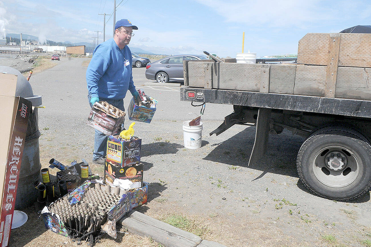 Port Angeles Parks and Recreation Department worker Richard Foster picks up spent fireworks on Tuesday at Sail and Paddle Park on Ediz Hook. Despite a city-wide ban on fireworks on Port Angeles, many people purchased the devices in Clallam County and nearby Native American reservations and brought them into town for Independence Day celebrations. (Keith Thorpe/Peninsula Daily News)