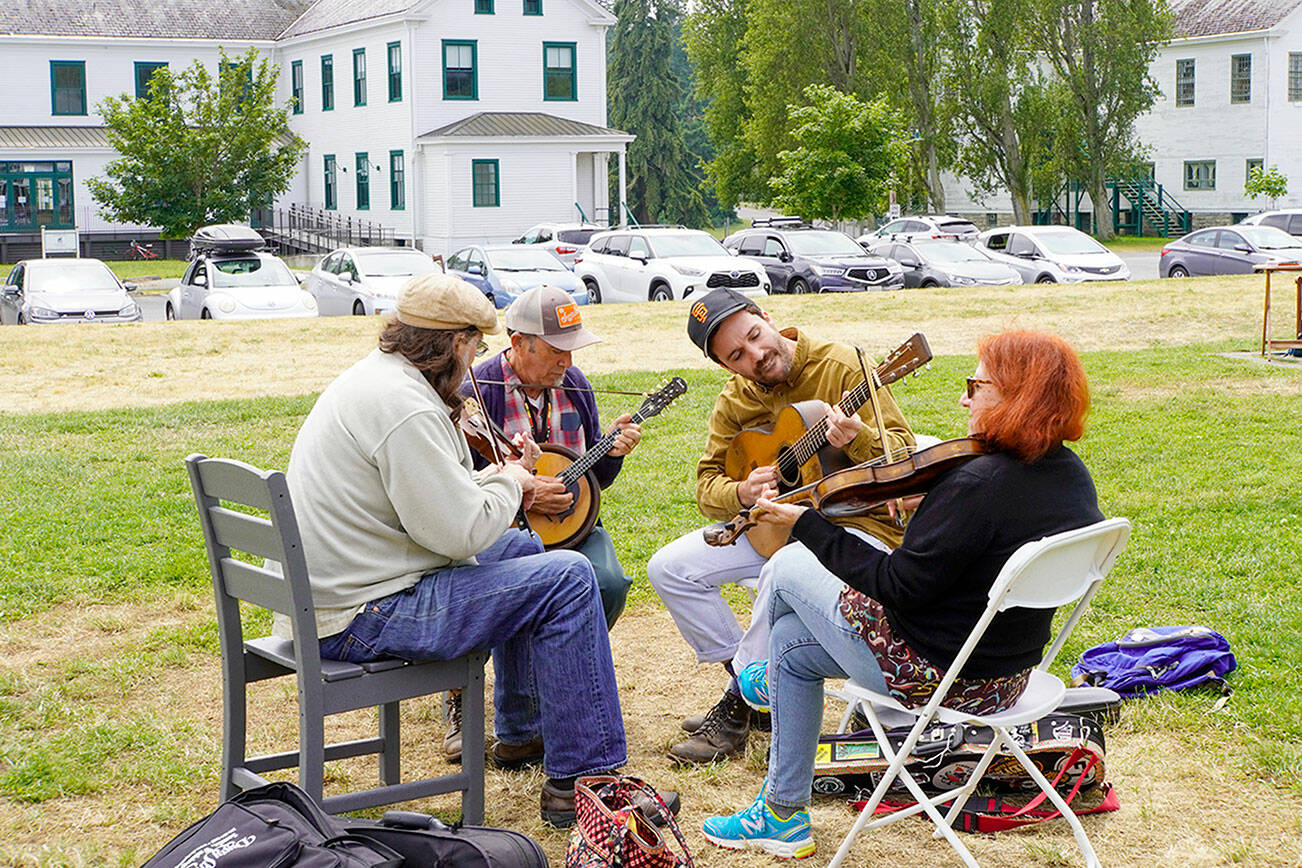 After a three-year hiatus, the popular Fiddle Tunes is back at Centrum with workshops and performances culminating in a Fiddle Tunes finale on Littlefield Green at Fort Worden State Park on Saturday. Sharing tunes at Fort Worden Commons on Tuesday afternoon are, from left: WB Reid of Seattle, Paul Rangell and son Benny of Santa Cruz, Calif., and Suzy Thompson of Berkeley, Calif. Thompson is a past Artistic Director of the Fiddle Tunes. (Steve Mullensky/for Peninsula Daily News)
