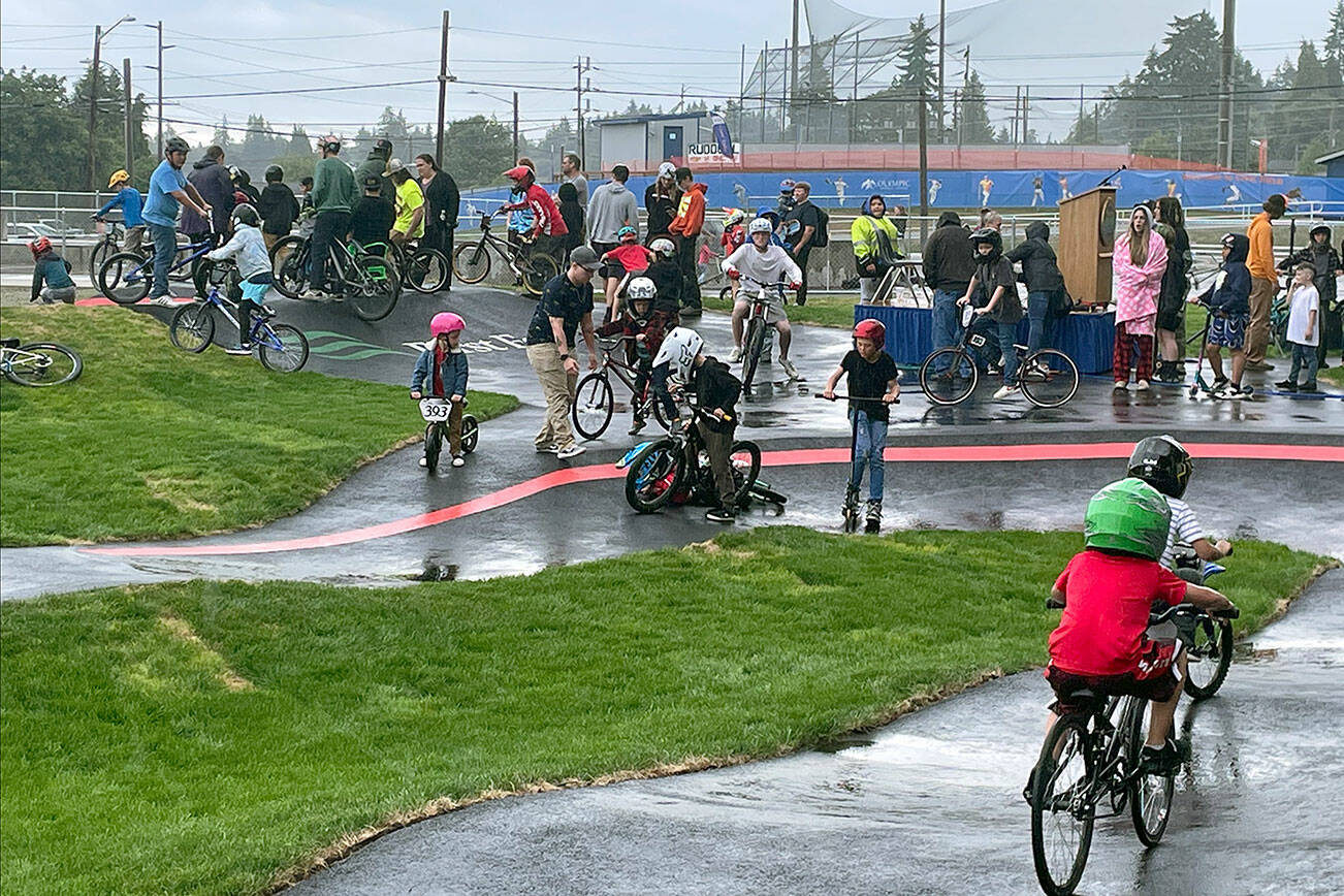 Kids on BMX bikes, mountain bikes, skateboards and scooters waited patiently through a grand opening ceremony of ribbon-cutting, remarks and recognitions, so they were more than ready to try out the new pump track Wednesday at Erickson Playfield. First announced three years ago, the 14,442-square-foot pump track is the largest in the Pacific Northwest built by Velosolutions and it’s the first adaptive track in the country. Port Angeles Parks & Recreation and Lincoln Park BMX Association led the project, which will provide a free, safe and all-ages recreational outlet located in the center of the city. (Paula Hunt/Peninsula Daily News)