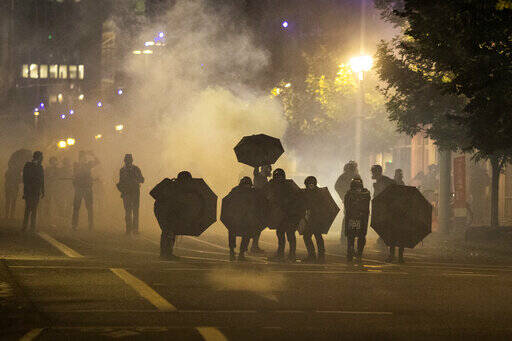 Tear gas fills the air during protests in Portland, Ore., on Sept. 18, 2020. Questions posed by lawmakers, medical workers and experts about the safety of tear gas remain unanswered, even after more than a dozen U.S. senators asked a congressional watchdog to look into the issue. (Paula Bronstein/The Associated Press)