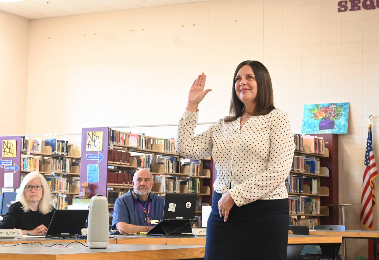 New Sequim School District Superintendent Regan Nickels takes her oath of office at a school board meeting Monday. Looking on are school board directors Maren Halvorsen and Jim Stoffer. (Michael Dashiell / Olympic Peninsula News Group)