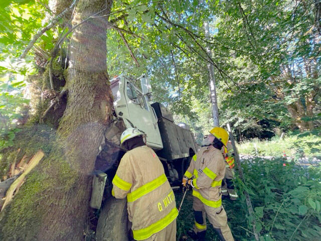 Clallam Fire District 4 firefighters remove a truck from a tree on Wednesday.