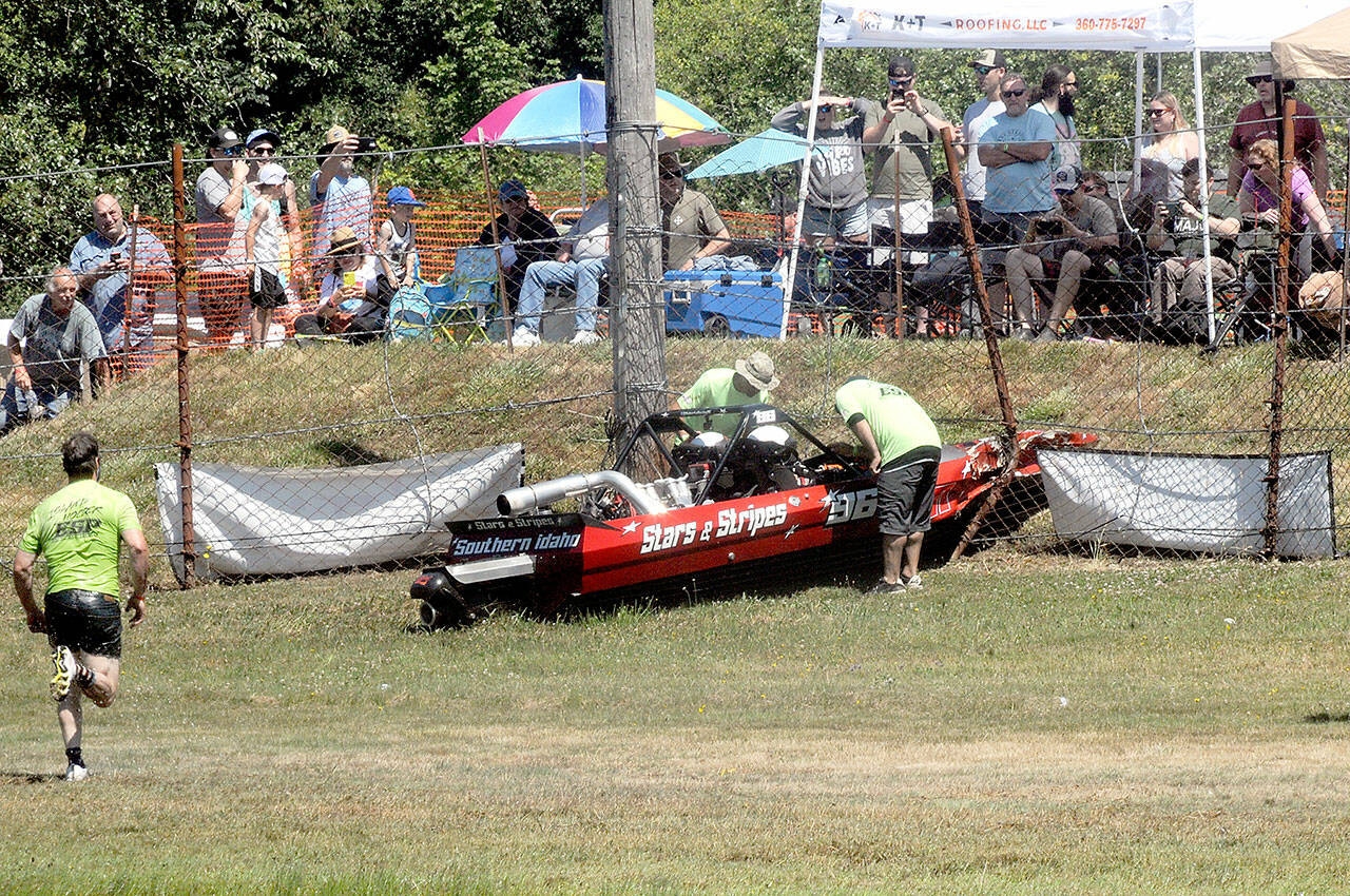 “Island hopper” safety personnel race to the Starts & Stripes boat after driver Burt Roberts and navigator Nichole Heaton left the Extreme Sports Park track and crashed nose-first through a safety fence on Saturday during sprint boat races in Port Angeles. The crew was apparently uninjured in the incident and the boat was later trailered back to the pits. (Keith Thorpe/Peninsula Daily News)