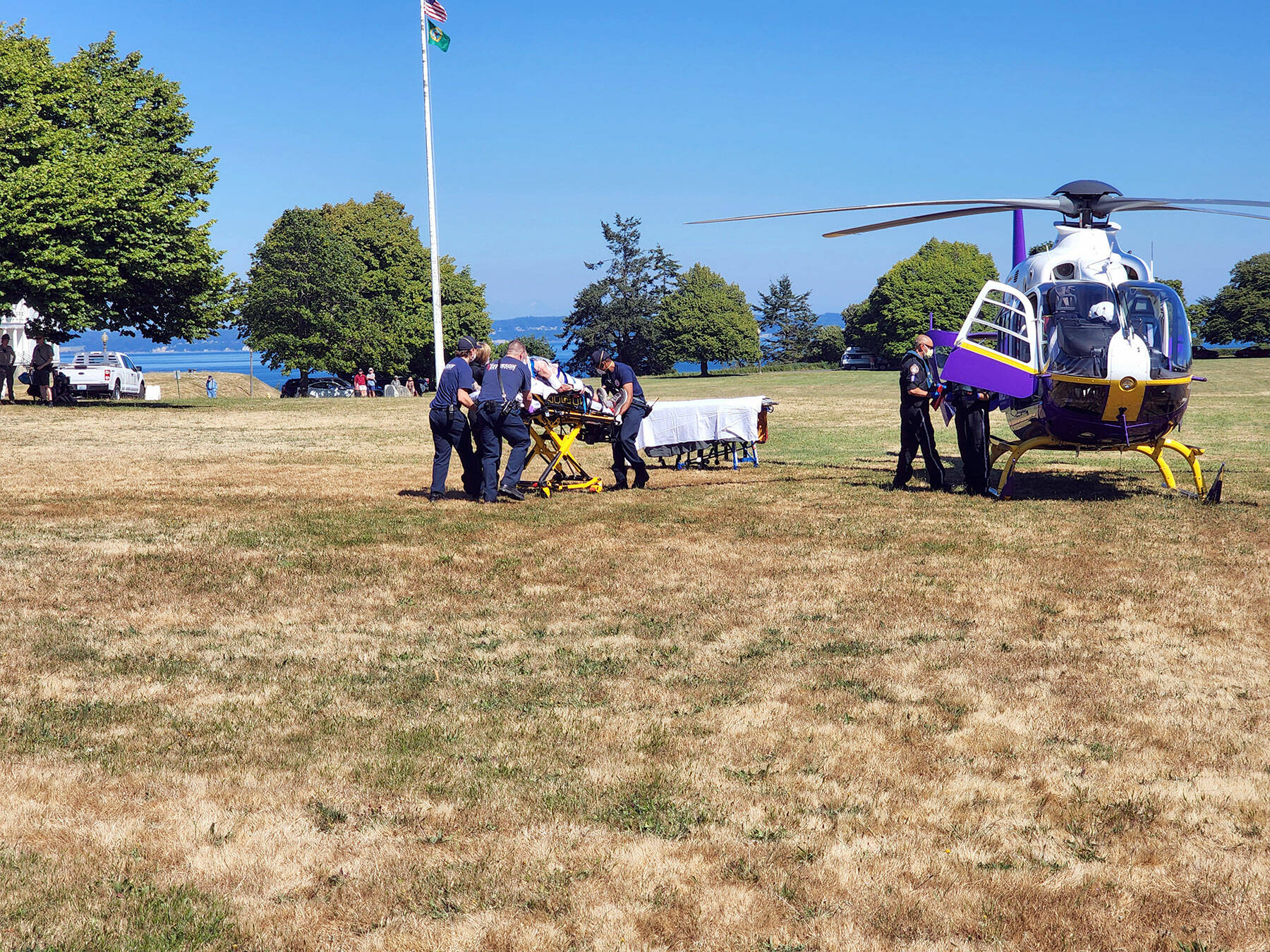 East Jefferson Fire Rescue personnel assist with loading an injured hiker onto a helicopter from Harborview Medical Center in Seattle on Tuesday afternoon. The unidentified elderly man had fallen on a trail by Fort Wordens Battery Tolles. (East Jefferson Fire Rescue)