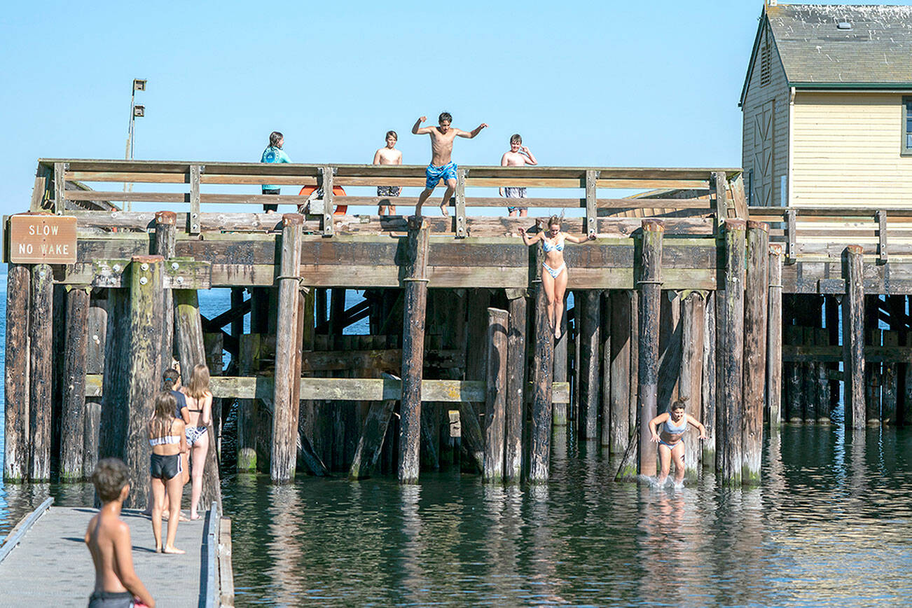 A group of youths cool off by jumping into the cove at the Marine Science Center at Fort Worden State Park on Tuesday. (Steve Mullensky/for Peninsula Daily News)