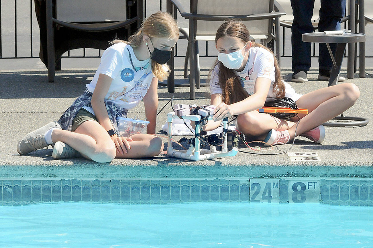 Keith Thorpe/Peninsula Daily News
Remotely operated vehicle teammates Stella Fradkin, left, and Cate Chance, both 12 from Port Angeles, make final adjustments to their underwater craft before competing in an obstical course on Friday at the swimming pool of the Red Lion Hotel in Port Angeles. Four teams of the Feiro Marine Life Center's summer ROV camp took part in a competition to put their vechicles through a series of tasks with points awarded for accuracy and time.
