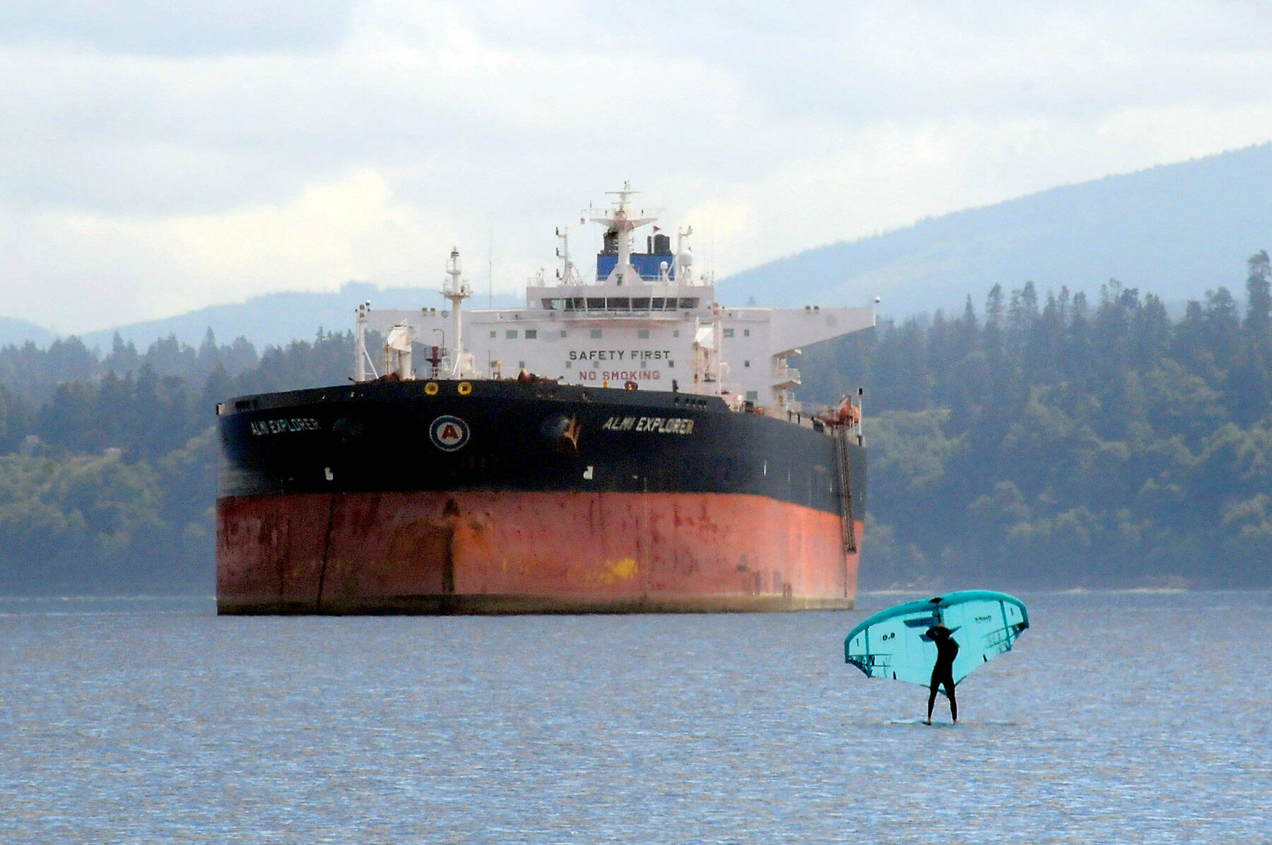 A wind foiler makes their way across the waters of Port Angeles Harbor against a backdrop of the tanker ship Almi Explorer. Moderate breezes from the Strait of Juan de Fuca made for pleasant conditions for wind-driven sports. (Keith Thorpe/Peninsula Daily News)