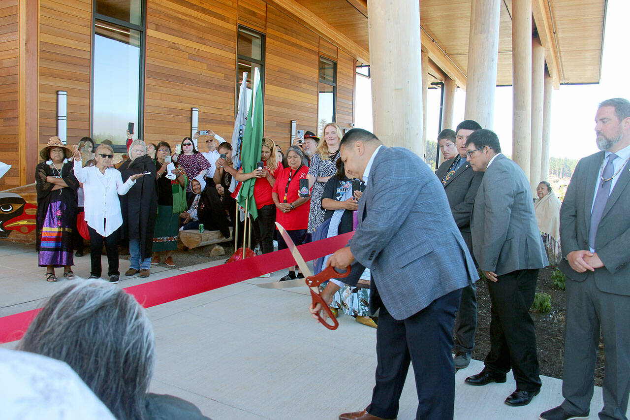 Quileute Tribal Council Chairman Douglas Woodruff Jr. prepares to cut the ribbon at the Quileute Tribal School Blessing Ceremony held Friday morning at La Push. Looking on from behind are council members Rio Jaime, Tony Foster and Skyler Foster. Council member Zachary Jones was not available. (Christi Baron/Olympic Peninsula News Group)