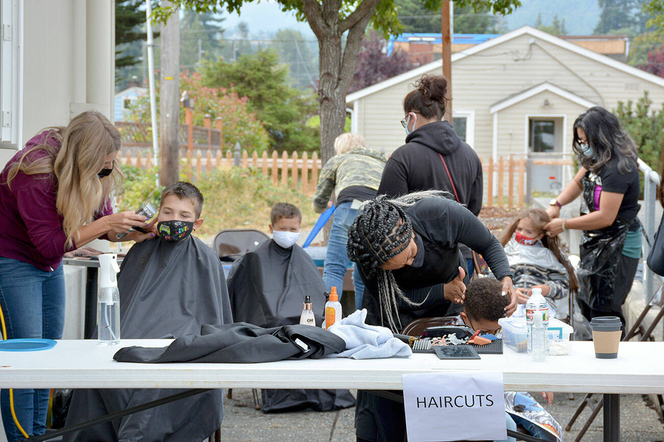 Hair stylists cut student's hair during the 2021 Back to School Fair.
