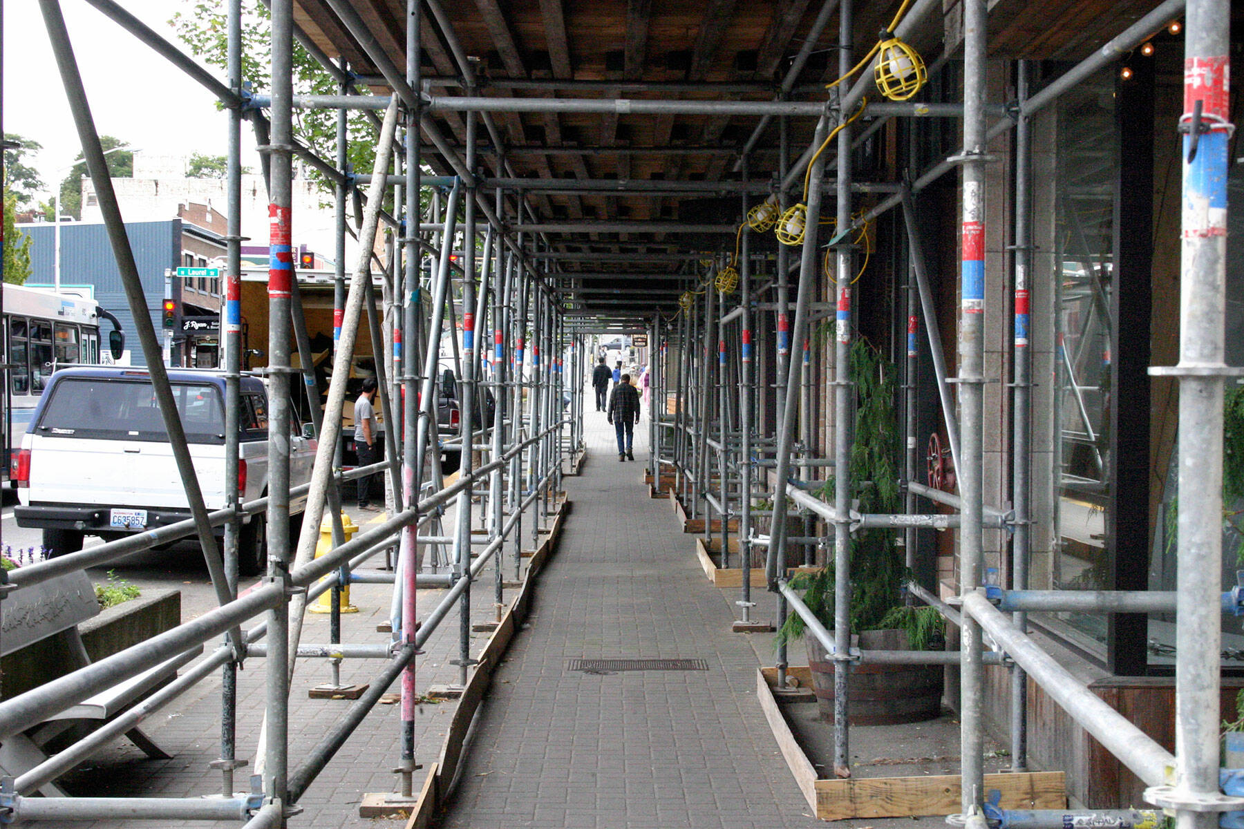 Scaffolding covers a section of the sidewalk in the 100 block of West First Street to support workers as they upgrade the the facade on Lee Plaza. (Keith Thorpe/Peninsula Daily News)