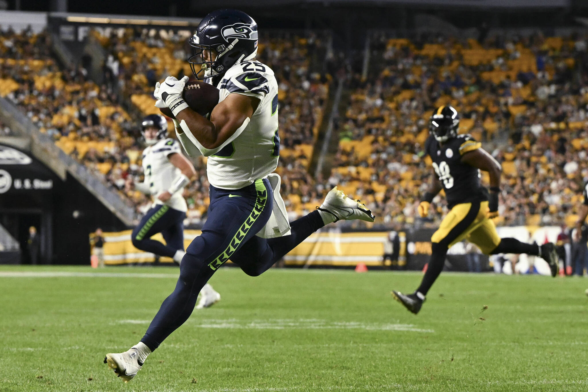 Seattle Seahawks running back Travis Horner (25) makes a catch for a 2-point conversion as Pittsburgh Steelers defensive end DeMarvin Leal (98) pursues during the second half of an NFL preseason football game, Saturday, Aug. 13, 2022, in Pittsburgh. (AP Photo/Barry Reeger)