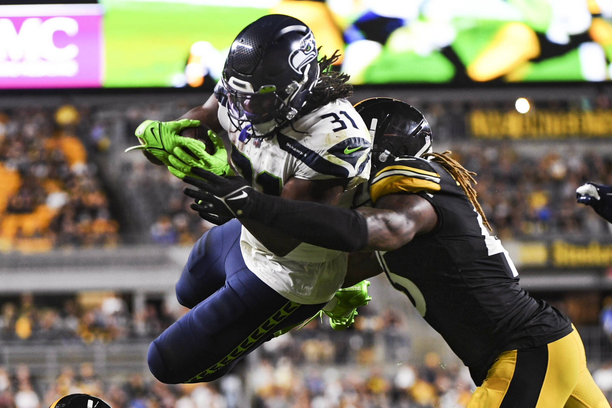 Seattle Seahawks running back DeeJay Dallas (31) leaps to the end zone for a touchdown as Pittsburgh Steelers linebacker Buddy Johnson (45) hits him during the second half of an NFL preseason football game Saturday, Aug. 13, 2022, in Pittsburgh. (AP Photo/Barry Reeger)