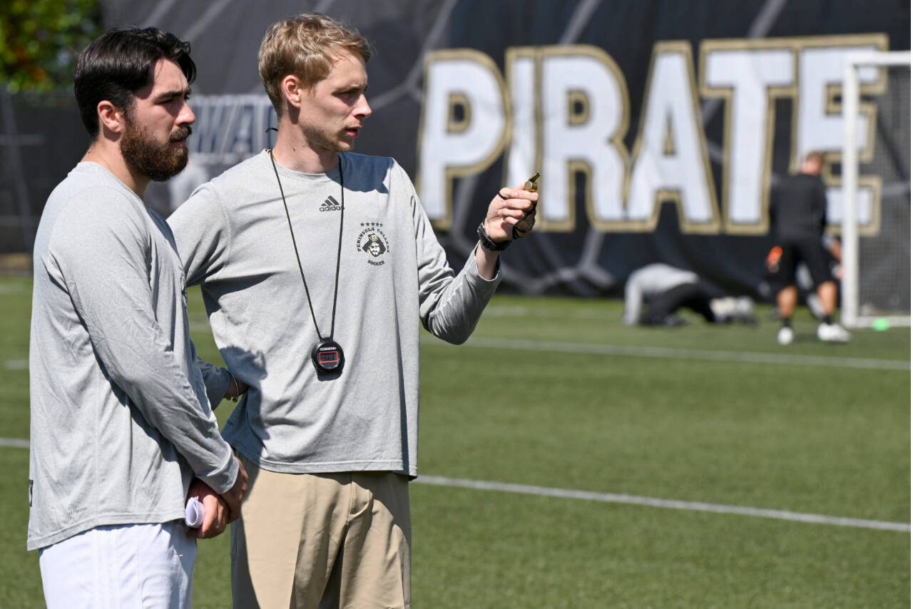 Peninsula College men’s soccer coach Jake Hughes, right, talks with assistant Jesse Salgado during practice earlier this month at Wally Sigmar Field. The Pirates begin their season Thursday at home with a game against Wenatchee CC. (Photo courtesy of Peninsula College)