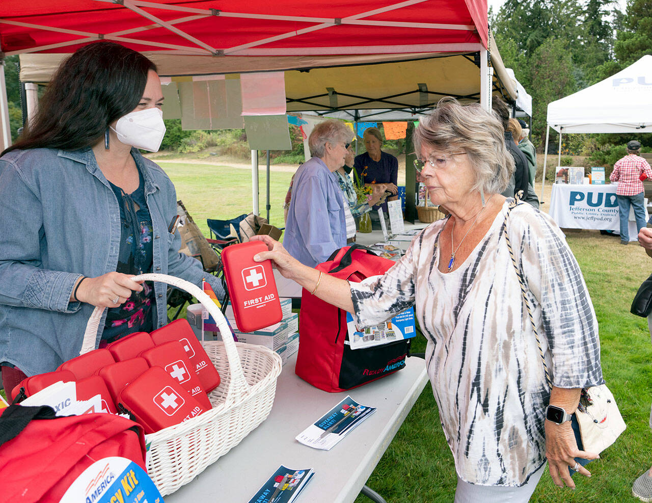 Carol Riley of Port Ludlow receives a free first aid kit from Apple Martine, director of Jefferson County Public Health, during the emergency preparedness demonstrations at HJ Carroll Park in Chimacum on Saturday. (Steve Mullensky/for Peninsula Daily News)
