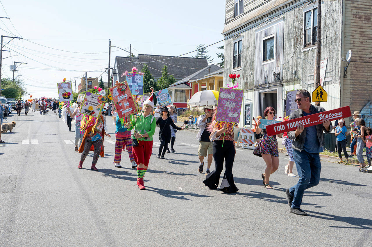 Uptown business owners and operators march down Lawrence Street during the Uptown Street Fair parade on Saturday. (Steve Mullensky/for Peninsula Daily News)