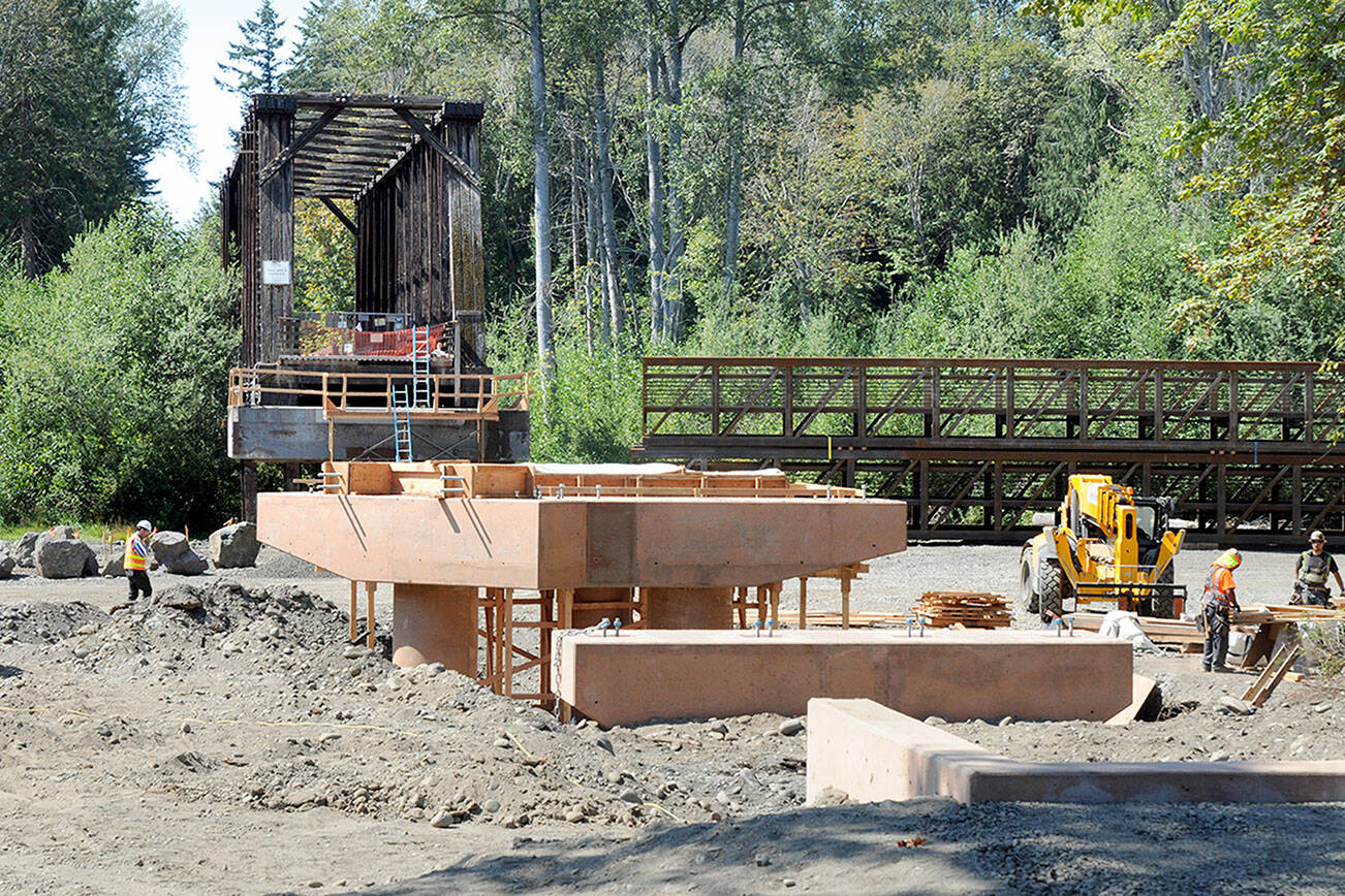 A construction crew prepares support structures for a new elevated walkway that will link the historic railroad trestle to the Dungeness River Nature Center at Railroad Bridge Park in Sequim and the existing Olympic Discovery Trail. The work is part of a project to restore the floodplain of the Dungeness River while providing improved access to the plaza of the recently opened nature center. The new walkway will include a bypass span, providing a direct route for pedestrians and bicyclists using the trail. Work is expected to be completed this fall. (Keith Thorpe/Peninsula Daily News)
