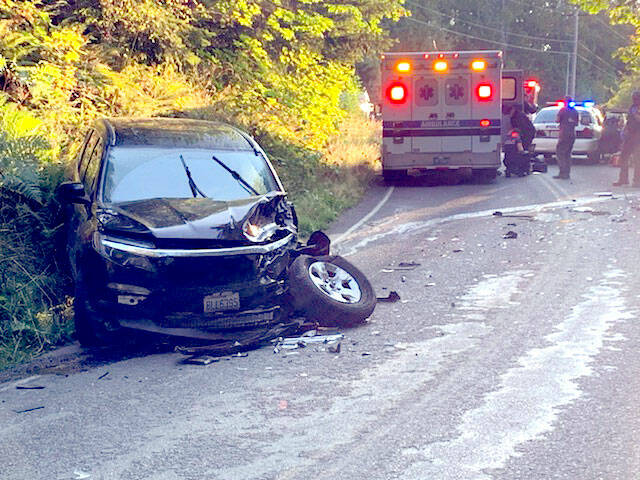 The stolen black 2022 Dodge sits mangled on the roadside. The pickup had collided head-on with a 2016 Honda Pilot after a short pursuit. (Clallam County Sheriff’s Office)