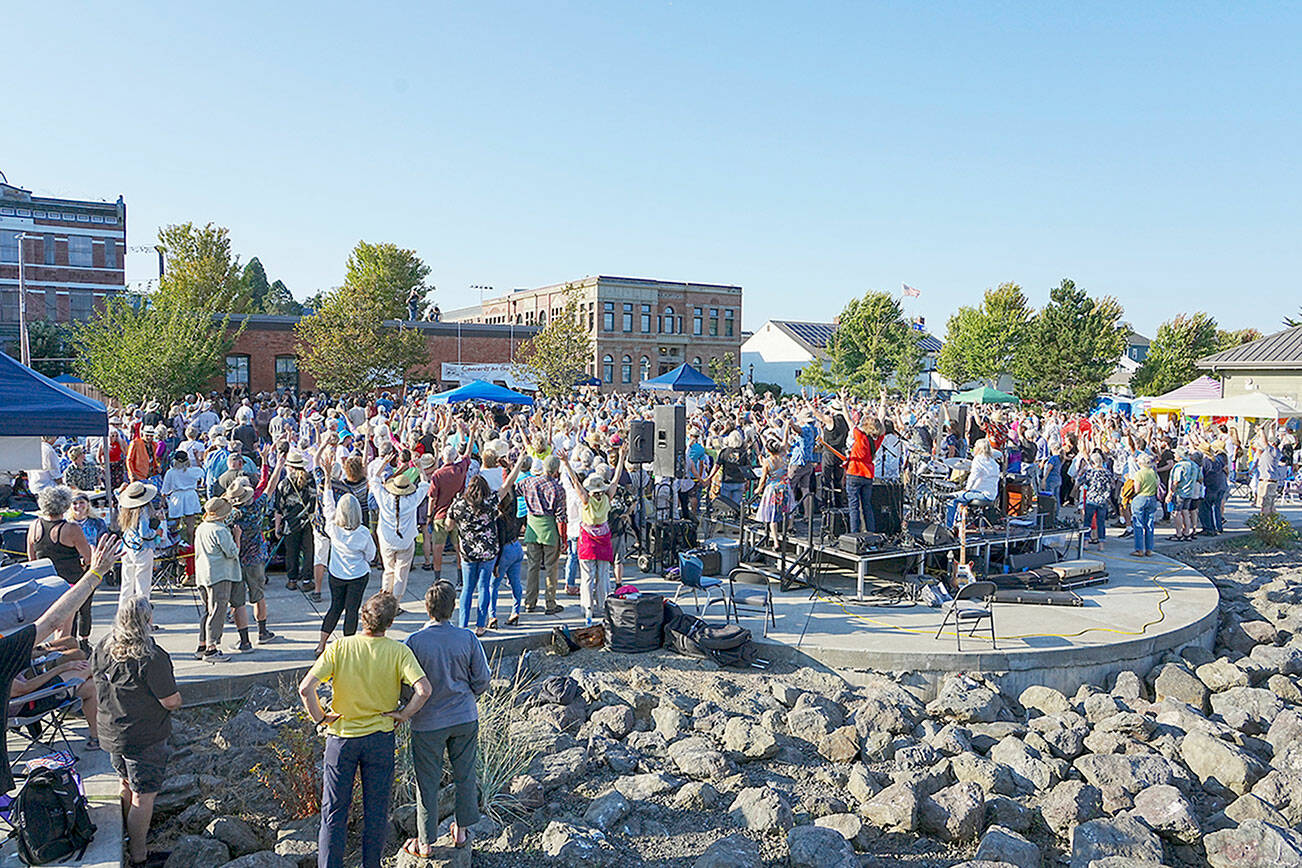 Steve Mullensky/for Peninsula Daily News


Several hundred people assembled at Pope Marine Park on Thursday for the final Concert on the Dock presented by the Port Townsend Main Street Association but also, for a Community Portrait that happened during intermission. Local photographer David Conklin, on the roof of the building, directs the crowd to raise their hands in celebration of the event. The photo session was over in less than 1/500th of a second.