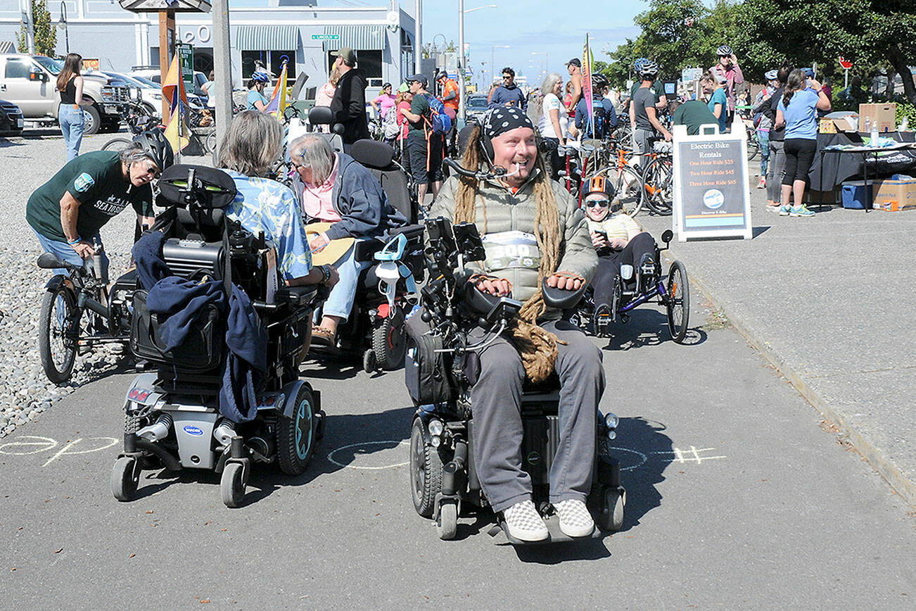 Ian Mackay of Agnew, center, prepares to lead a group of wheelchair, bicyclists, runners and others on a portion of Sea-to-Sound, a three-day, 74-mile multi-modal group ride along a section of the Waterfront Trail in Port Angeles on Saturday. The excursion, which followed numerous portions of the Olympic Discovery from west of Lake Crescent to the Larry Scott Trail in Jefferson County, ended Sunday. It was organized through Ian’s Ride, a nonprofit organization the advocates outdoor accessibility for all. (Keith Thorpe/Peninsula Daily News)