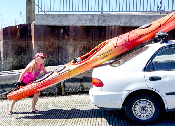 Jennifer Porter of Edmonds loads her 14-foot kayak after a morning on the water at Port Townsend Boat Haven on Monday. Porter attended the three-day THING Festival at Fort Worden State Park over the weekend and wanted to get some time on the water before going home. (Steve Mullensky/for Peninsula Daily News)