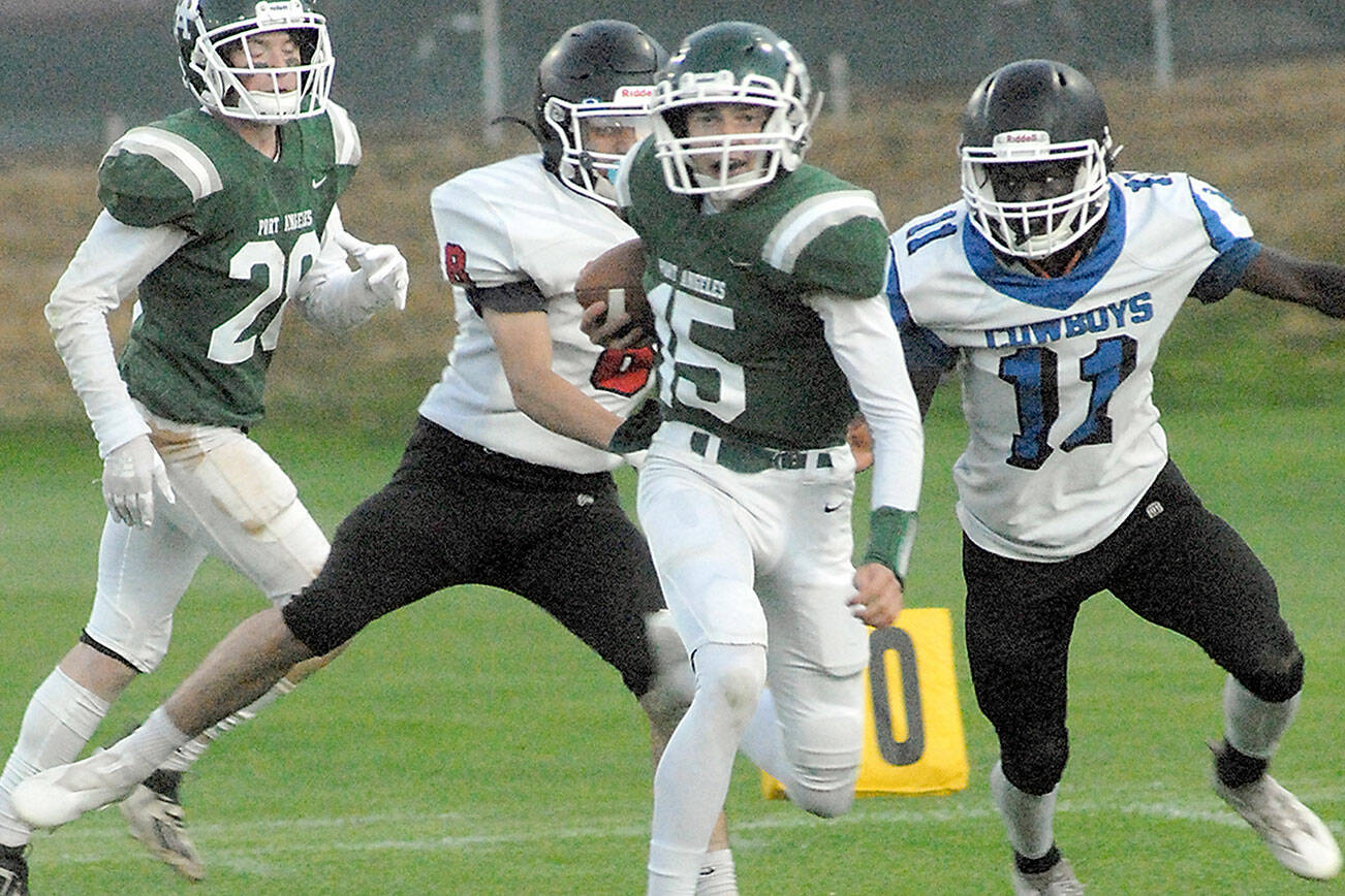 Keith Thorpe/Peninsula Daily News
Port Angeles' Parker Nickerson, center, slips past East Jefferson's Lonnie Kenney and Jerome Reaux Jr., right, as Nickerson's teammate, Brantyn Fisler, left, follows behind on Friday at Port Angeles Civic Field.
