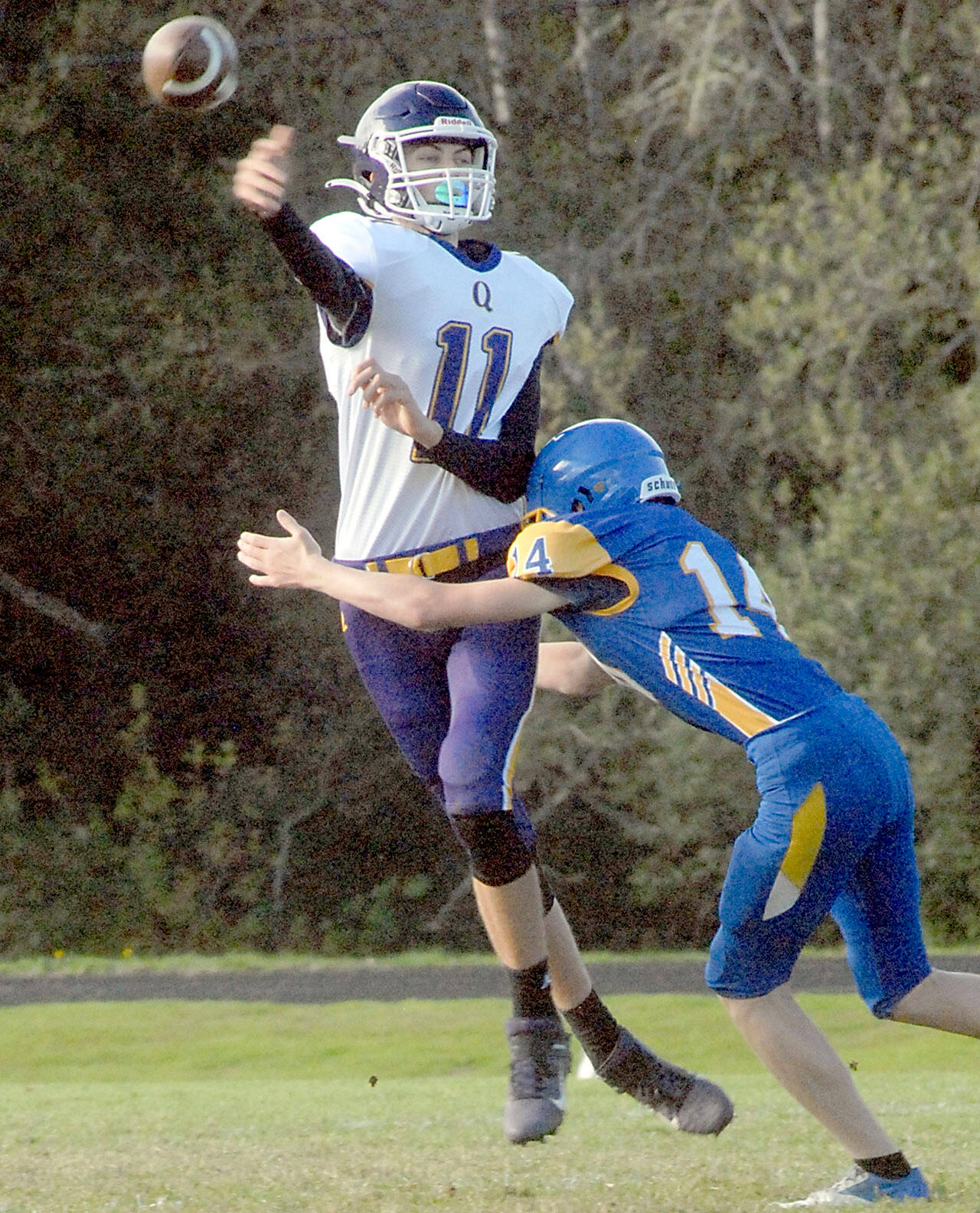 Quilcene quaterback Nathan Kieffer passes before being tackled by Crescent’s Cole Grooms on Thursday at Crescent High School. (Keith Thorpe/Peninsula Daily News)