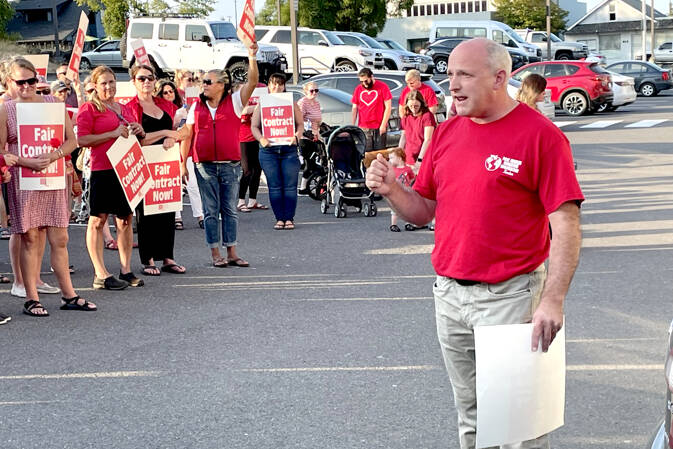 Members of the Port Angeles Education Association and its president John Henry, right, rallied at the Port Angeles School District’s Lincoln Center administrative building Wednesday evening just hours before the union called for a strike to begin Tuesday if an agreement is not reached. (Paula Hunt/Peninsula Daily News)