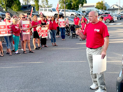 Members of the Port Angeles Education Association and its president John Henry, right, rallied at the Port Angeles School District’s Lincoln Center administrative building Wednesday evening just hours before the union called for a strike to begin Tuesday if an agreement is not reached. (Paula Hunt/Peninsula Daily News)