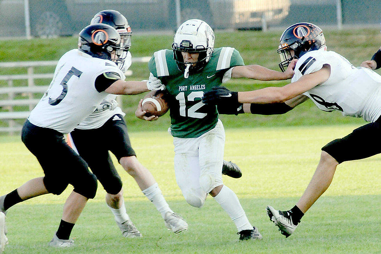 KEITH THORPE/PENINSULA DAILY NEWS
Port Angeles' Kason Albaugh, center, tries to escape the Blaine defense of Logan Villarreal, left, and Alejandro Moser-Hernandez, right, on Friday night at Port Angeles Civic Field.