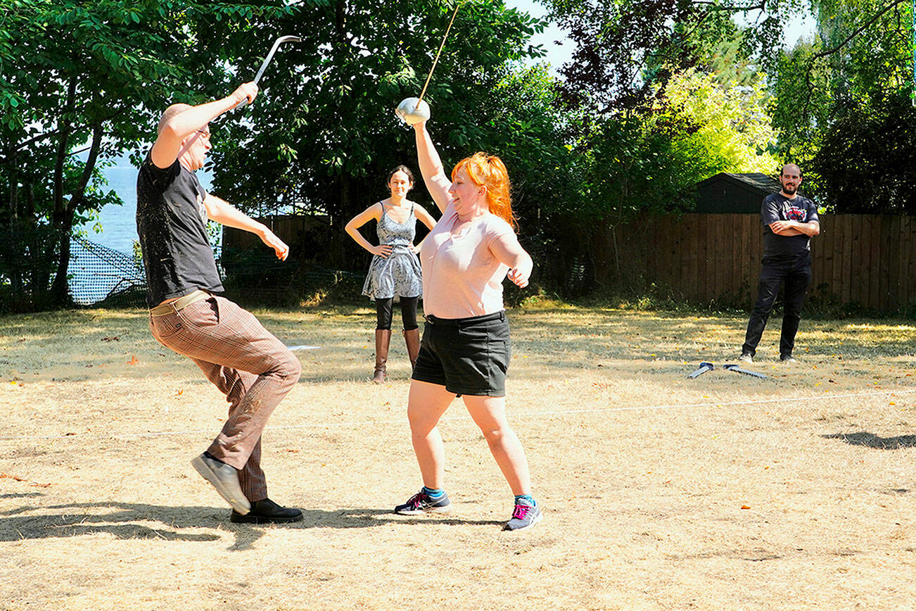 Steve Mullensky/for Peninsula Daily News

Actors Casey Bowen, left, as Paris and Emily Huntingford, right as Romeo, rehearse sword play before the opening of Key City Public Theatre’s Shakespeare in the Park production of Romeo and Juliet at Chetzemoka Park on Friday night. The play will be performed today and Sunday at 6 p.m. Director Mike Lion observes from the background.