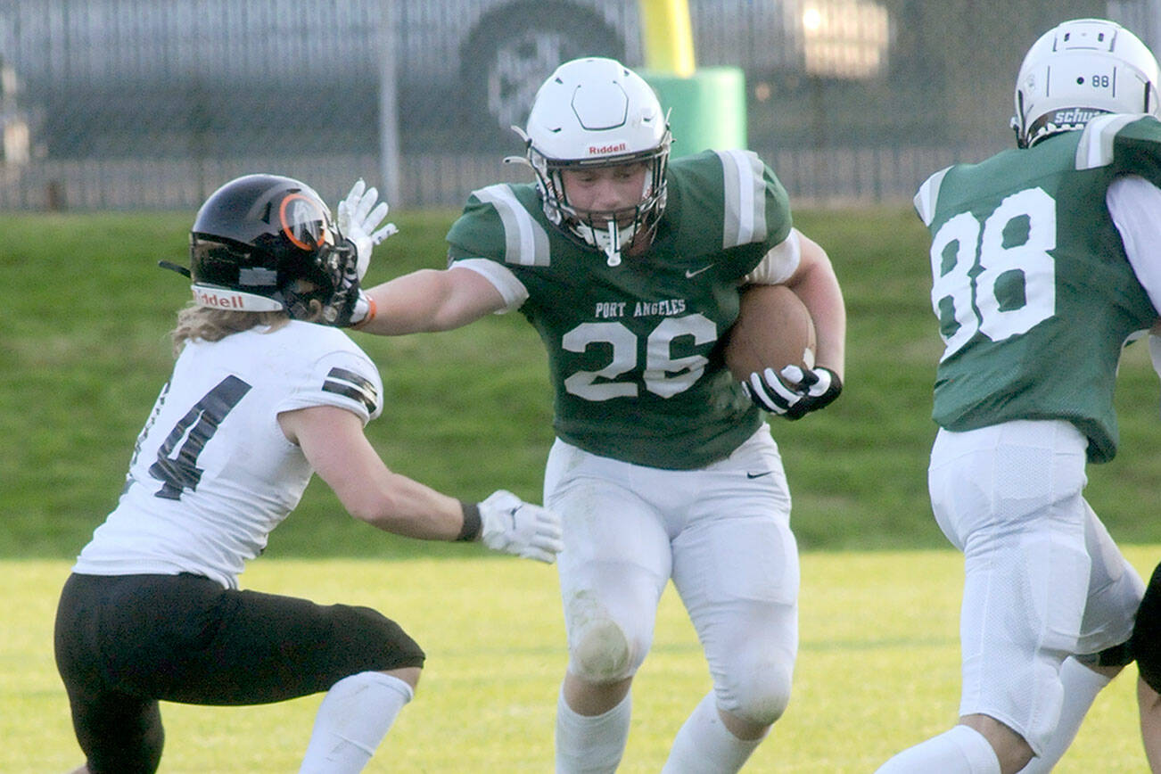 Keith Thorpe/Peninsula Daily News
Port Angeles' Landyn Jones, center, pushes off a Blaine defender after receiving a block from teammate Cole Beeman, right, on Friday in Port Angeles. Jones gained 82 yards rushing last week, much of it on misdirection plays.