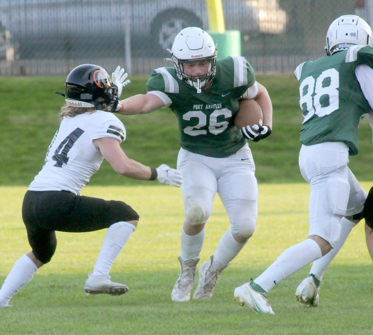 Port Angeles’ Landyn Jones, center, pushes off a Blaine defender after receiving a block from teammate Cole Beeman, right, on Friday in Port Angeles. Jones gained 82 yards rushing last week, much of it on misdirection plays. (Keith Thorpe/Peninsula Daily News)