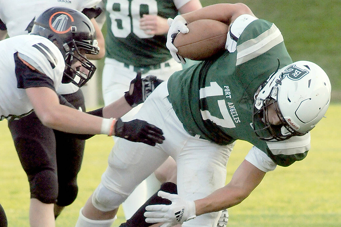 KEITH THORPE/PENINSULA DAILY NEWS
Port Angeles' Jason Hawes is brought down by Blain's Riley Ihde and Mallory Messenger, left, in second quarter play on Friday evening in Port Angeles.